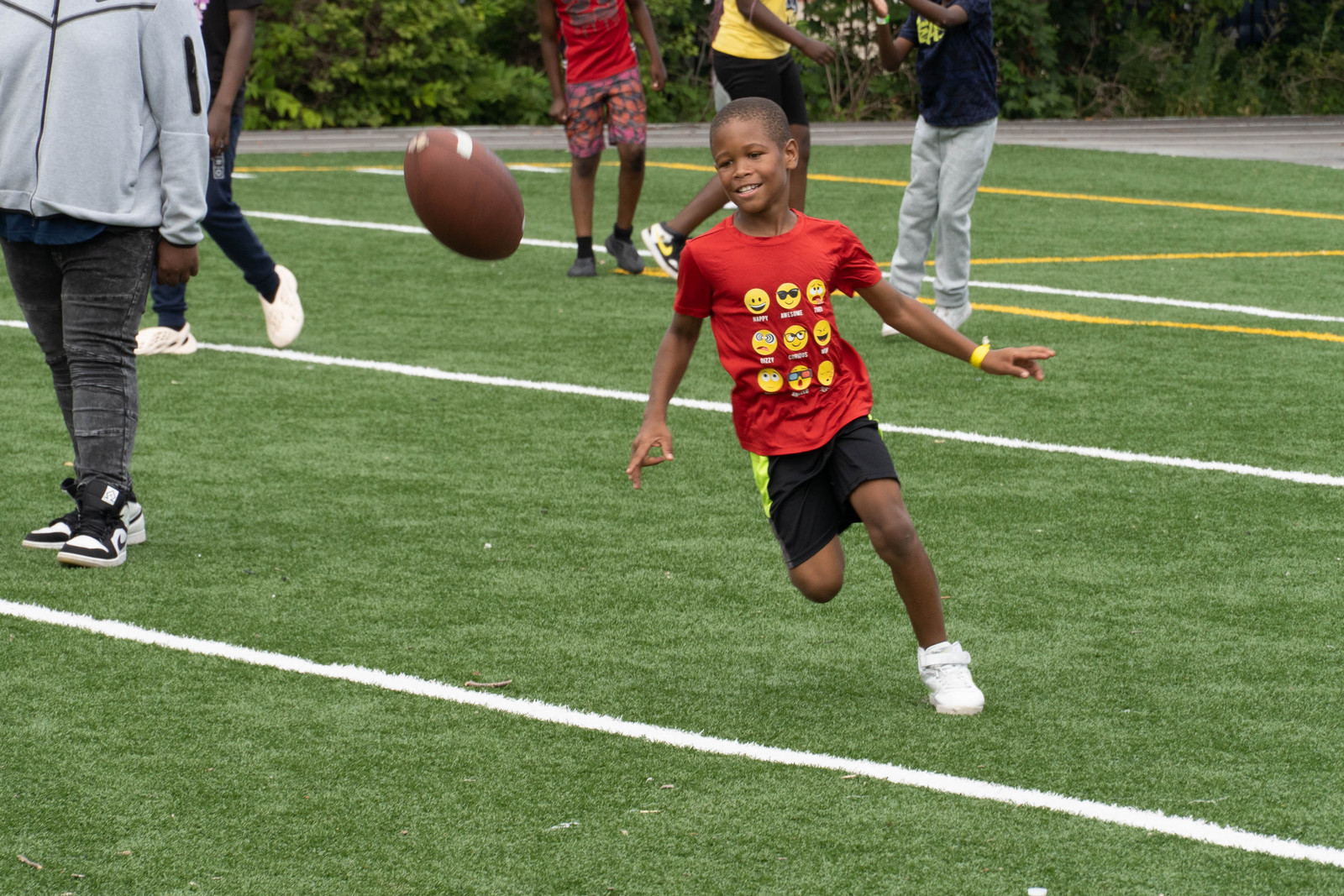 A child playing basketball alongside neighbors at an outdoor block-party gathering