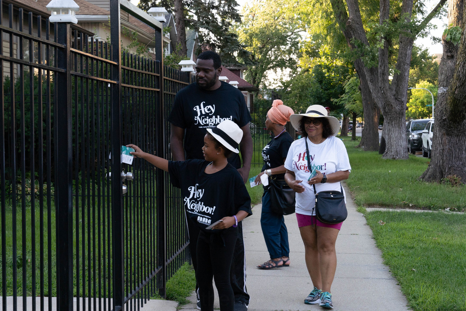 Neighbors of different generations walking together along a tree-lined South Shore sidewalk