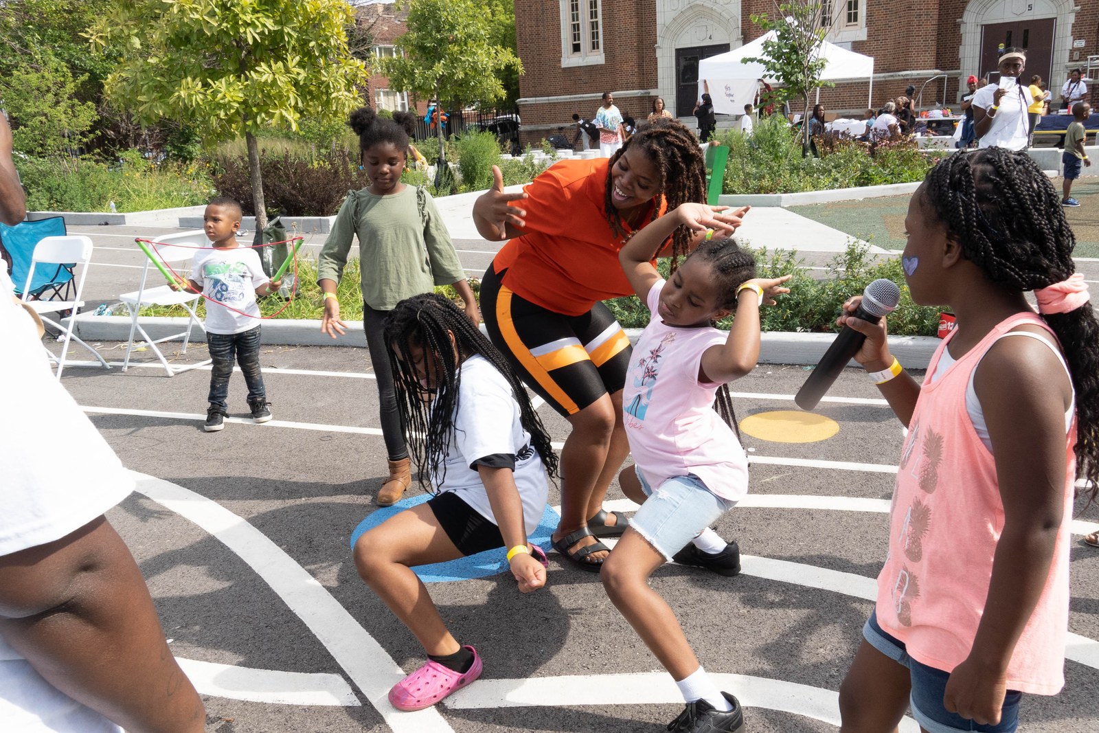 Children singing and dancing with neighbors at a block party
